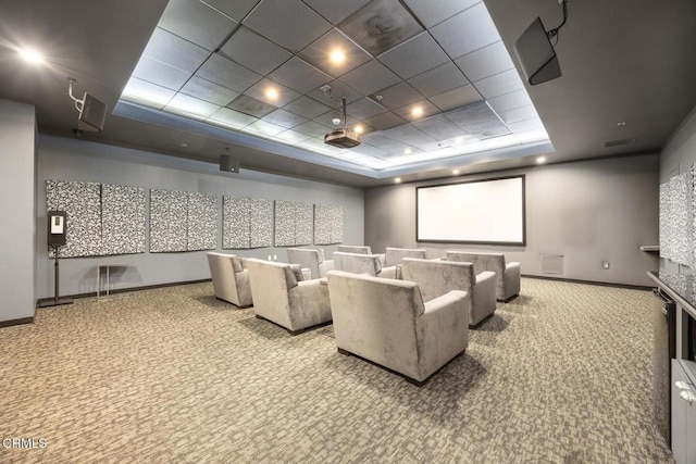 cinema featuring carpet, a raised ceiling, and baseboards