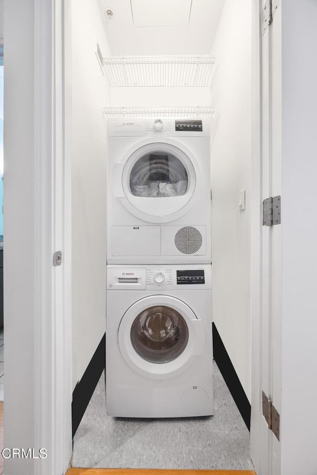 1100 Wilshire Blvd Unit 1808, Los Angeles, CA 90017 - laundry room featuring estacked washer and dryer and baseboards