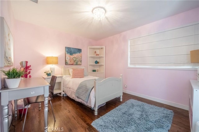 bedroom featuring wood finished floors and baseboards