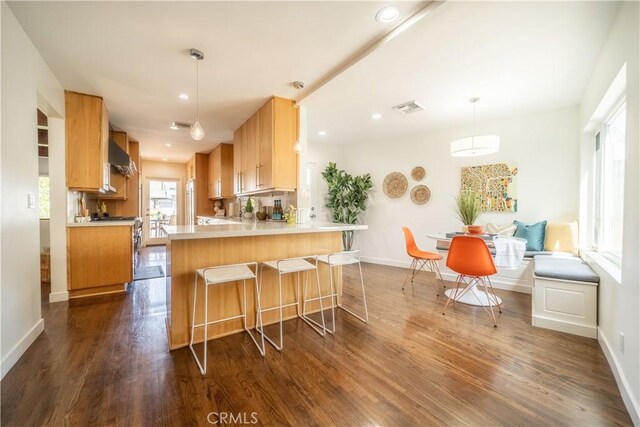 260 The Toledo, Long Beach, CA 90803 - kitchen featuring baseboards, a peninsula, dark wood-type flooring, visible vents, and wall chimney exhaust hood