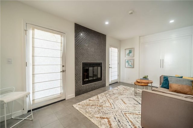 tiled living room featuring recessed lighting, a fireplace, and baseboards