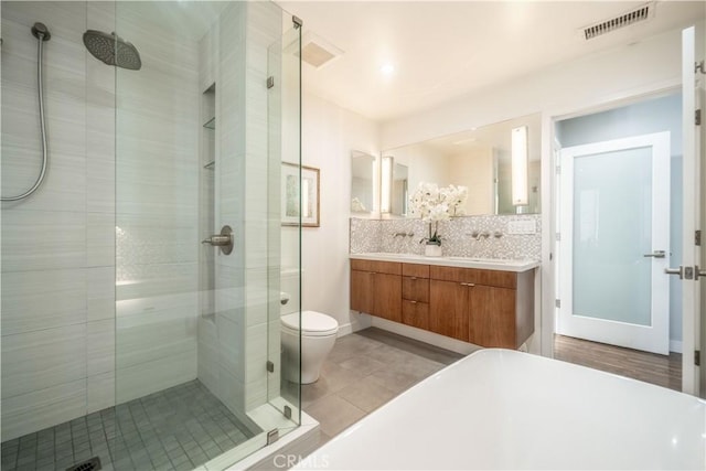 bathroom featuring tile patterned flooring, visible vents, a shower stall, decorative backsplash, and double vanity