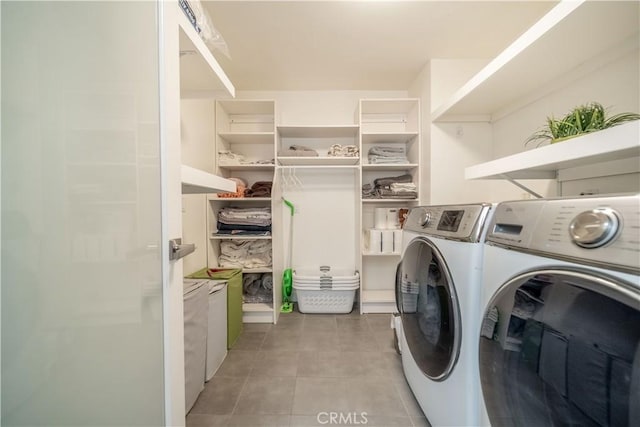 washroom featuring laundry area, tile patterned floors, and washing machine and clothes dryer