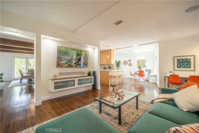 living area featuring wood finished floors, visible vents, and baseboards