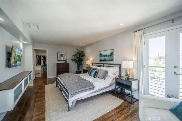 bedroom featuring dark wood-type flooring, recessed lighting, access to exterior, and a spacious closet