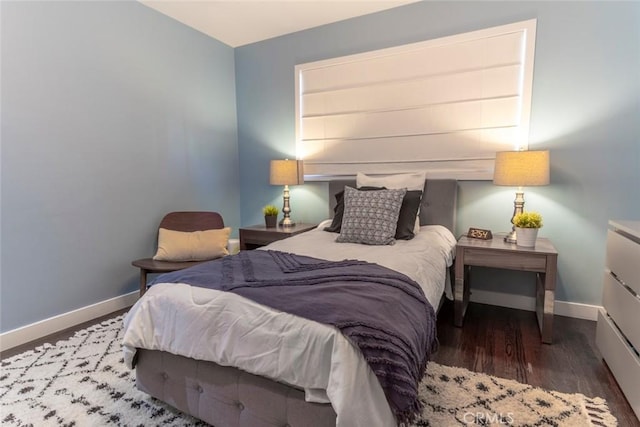 bedroom featuring baseboards and wood finished floors