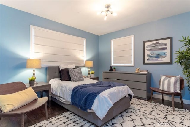 bedroom with baseboards and wood finished floors