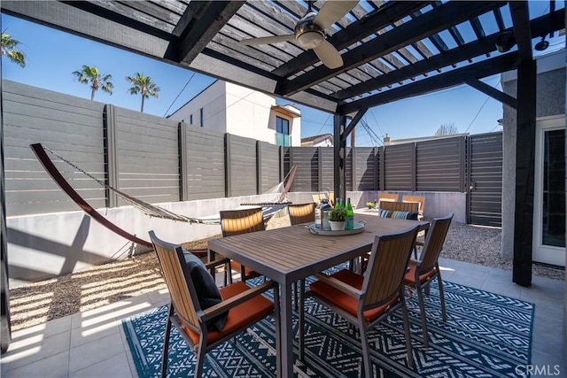 view of patio featuring outdoor dining space, a fenced backyard, and ceiling fan