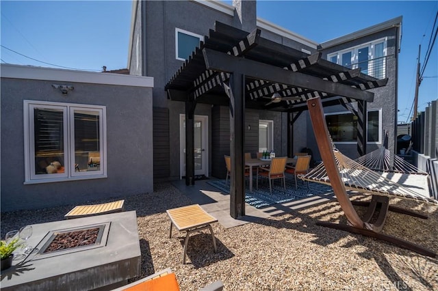 back of house with stucco siding, a patio, and a pergola