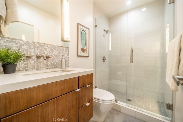 bathroom with a stall shower, backsplash, toilet, and vanity