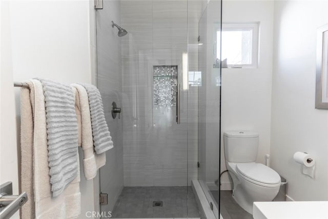 bathroom with a shower stall and toilet