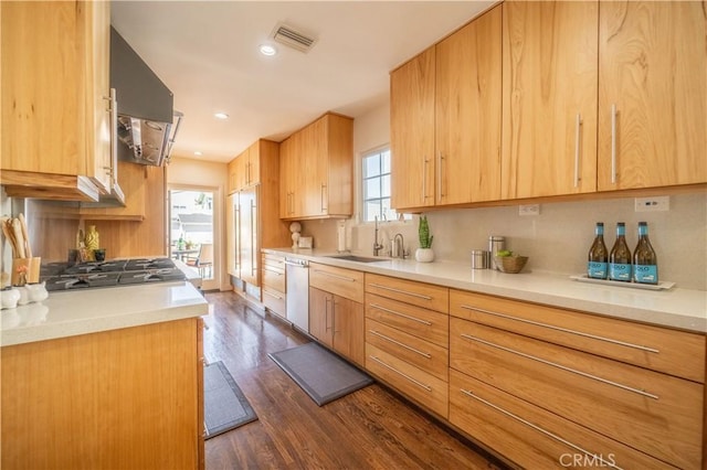 kitchen with dark wood finished floors, visible vents, light brown cabinetry, a sink, and dishwasher