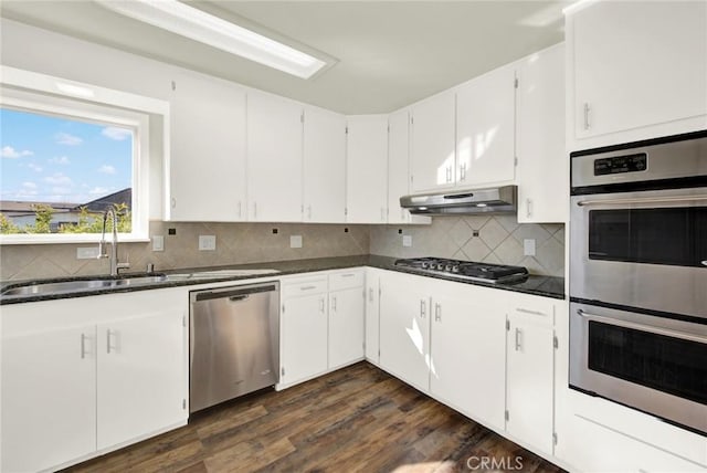 1495 S S, Corning, CA 96021 - kitchen featuring dark wood-style flooring, a sink, decorative backsplash, under cabinet range hood, and appliances with stainless steel finishes