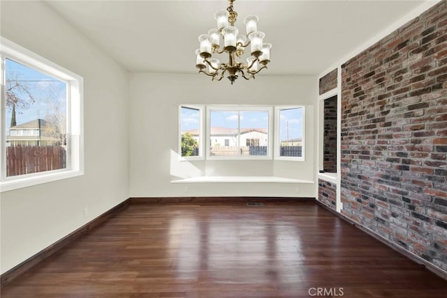 1495 S S, Corning, CA 96021 - unfurnished dining area featuring baseboards, a notable chandelier, wood finished floors, and brick wall