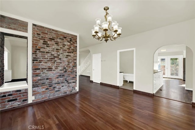 1495 S S, Corning, CA 96021 - unfurnished dining area featuring wood finished floors, stairway, arched walkways, brick wall, and baseboards