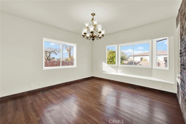1495 S S, Corning, CA 96021 - unfurnished room with visible vents, baseboards, an inviting chandelier, and dark wood-style flooring