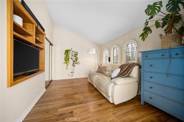 sitting room with lofted ceiling, wood finished floors, and baseboards