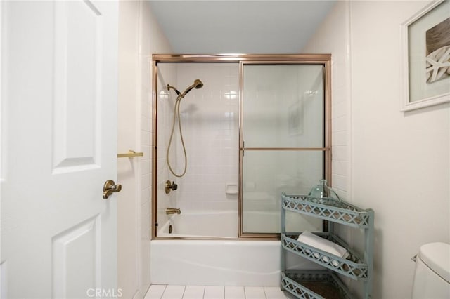 full bathroom with shower / bath combination with glass door, toilet, and tile patterned floors