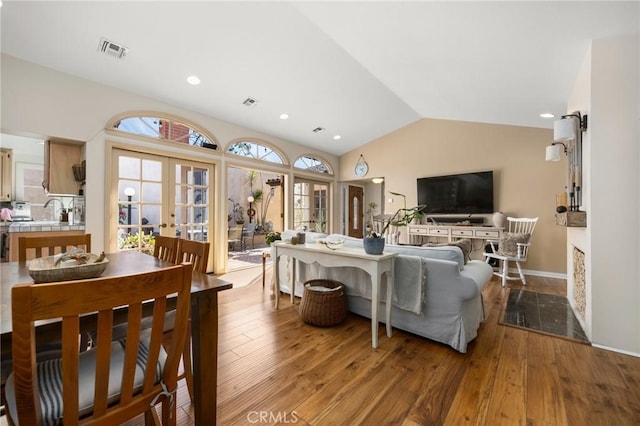 living area featuring visible vents, lofted ceiling, hardwood / wood-style floors, french doors, and recessed lighting