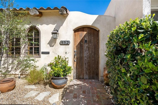 doorway to property featuring stucco siding