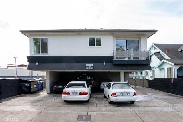 view of front of property with fence, driveway, an attached garage, and stucco siding