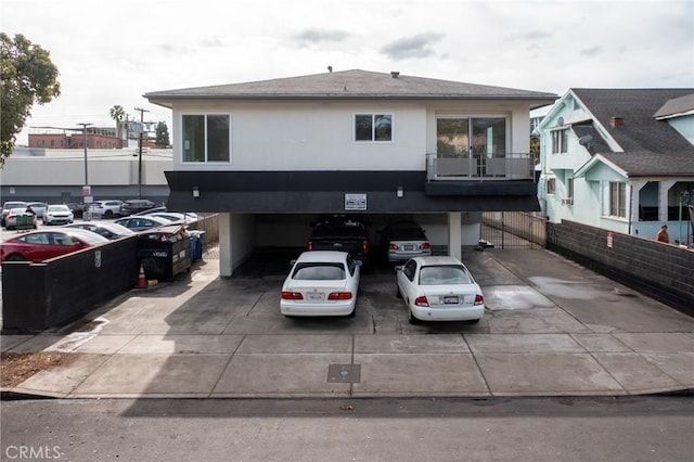 view of front of house with uncovered parking and stucco siding