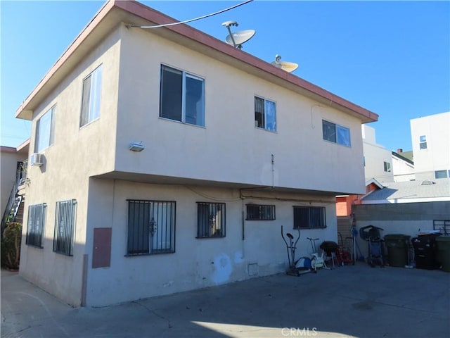 rear view of house featuring stucco siding