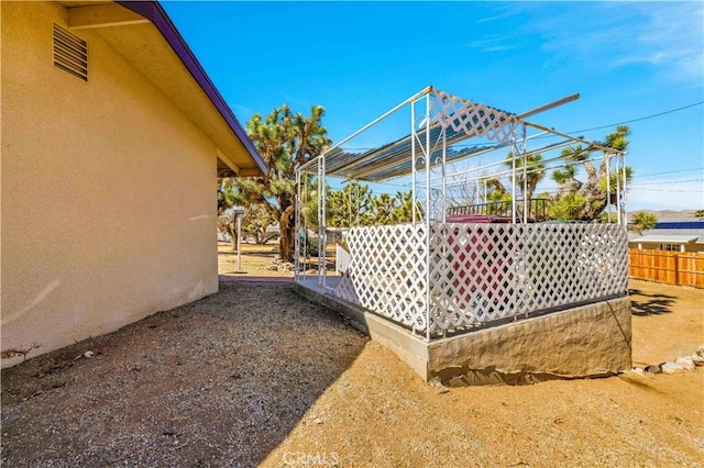 view of side of property featuring fence and stucco siding