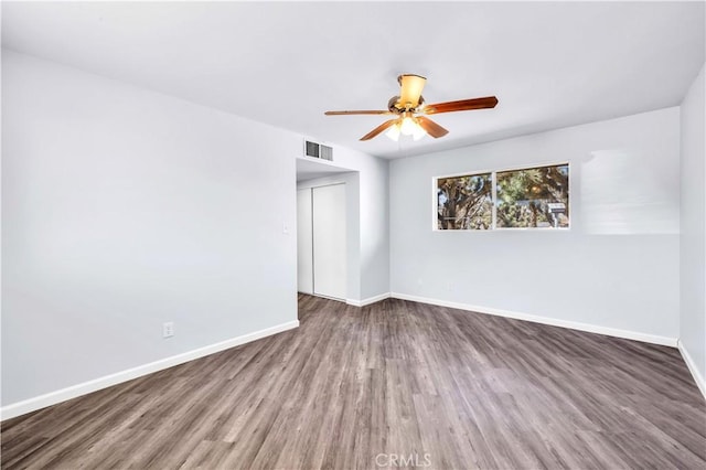 unfurnished room with visible vents, baseboards, and wood finished floors