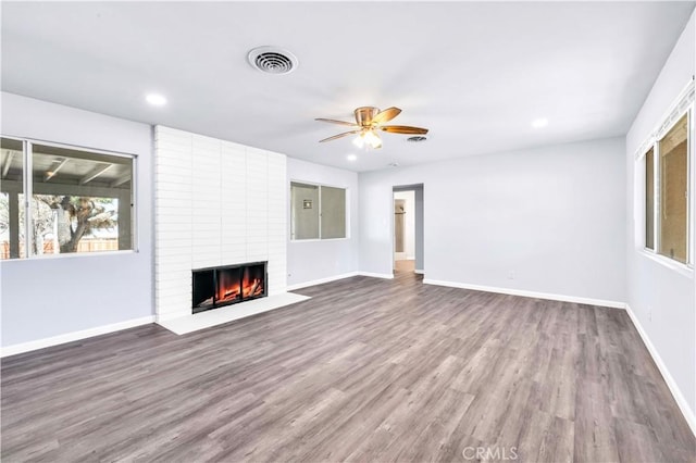 unfurnished living room with a fireplace, baseboards, and wood finished floors