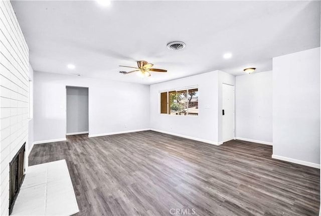 unfurnished living room with baseboards, visible vents, ceiling fan, dark wood-type flooring, and a fireplace