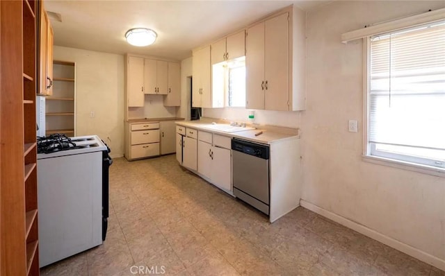 kitchen with white range with gas cooktop, baseboards, dishwasher, light floors, and a sink