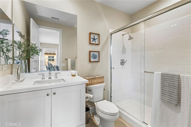 bathroom featuring visible vents, toilet, a stall shower, and vanity