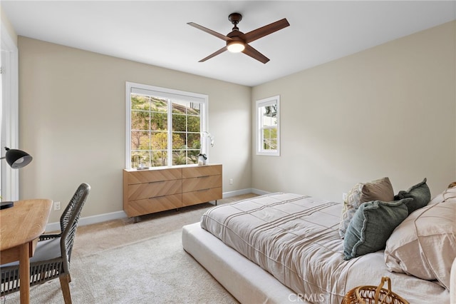 bedroom featuring light colored carpet, baseboards, and ceiling fan