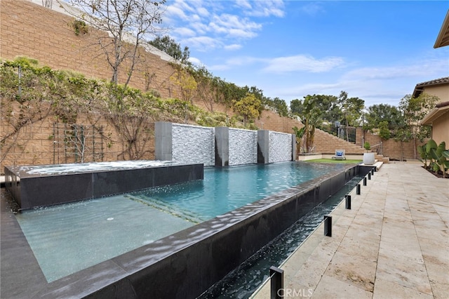 view of swimming pool with an infinity pool and a fenced backyard