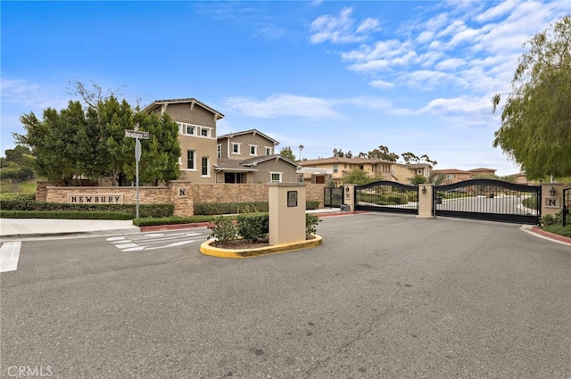 view of street with a gate, curbs, and a gated entry