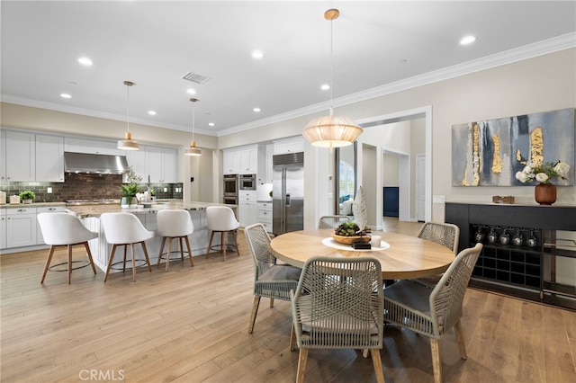 dining room with recessed lighting, visible vents, light wood-style flooring, and crown molding