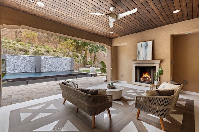 view of patio / terrace featuring an outdoor living space with a fireplace and ceiling fan