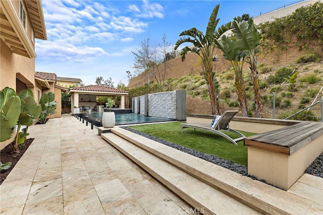 view of patio / terrace featuring a gazebo, a fenced backyard, and an outdoor pool