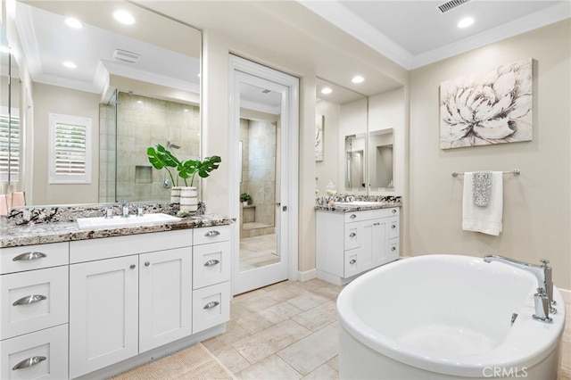 bathroom featuring a shower stall, two vanities, crown molding, and a sink