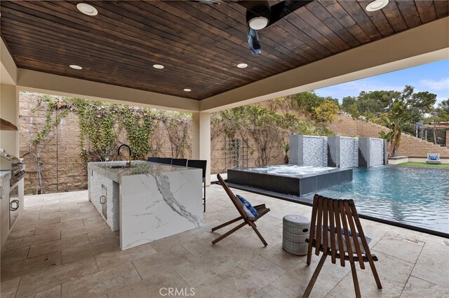 view of patio featuring a fenced in pool, outdoor dining area, a fenced backyard, and a sink