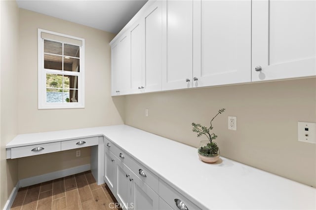 laundry area with baseboards and light wood-style floors