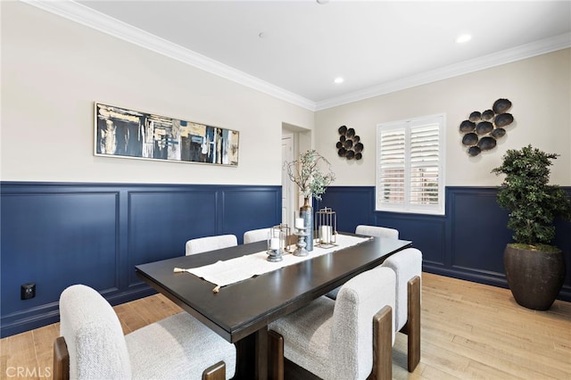 dining room with recessed lighting, a wainscoted wall, light wood finished floors, and ornamental molding