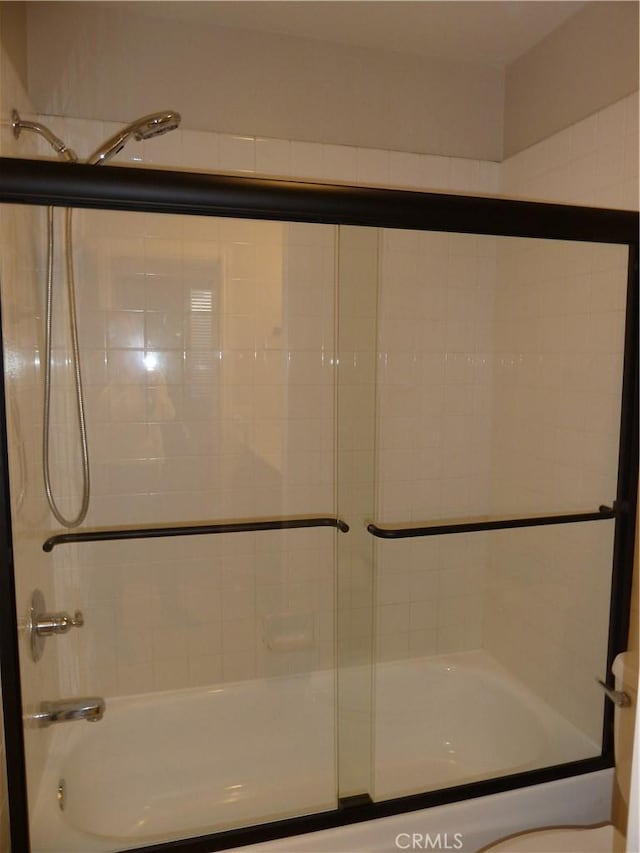 bathroom with combined bath / shower with glass door