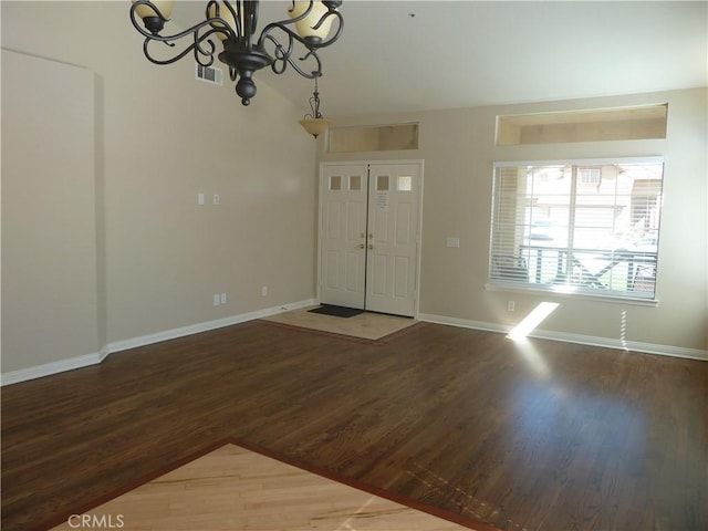 foyer entrance with a notable chandelier, wood finished floors, visible vents, baseboards, and vaulted ceiling