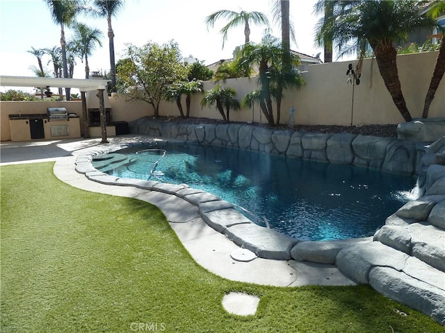 view of swimming pool featuring exterior kitchen, a fenced in pool, a fenced backyard, and a yard