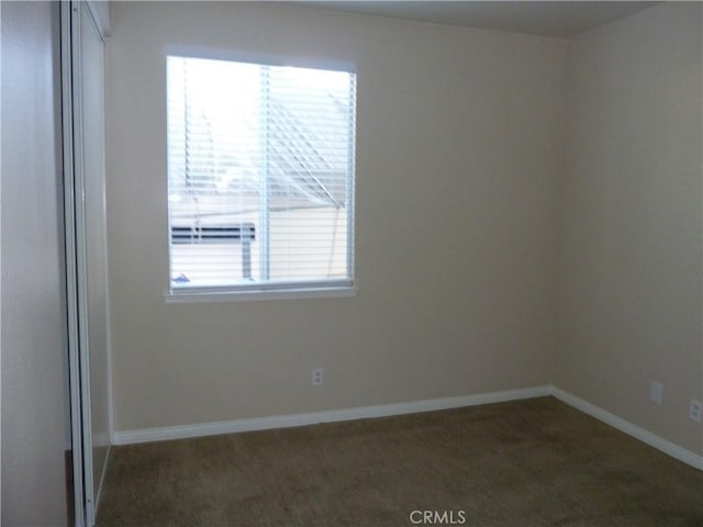 unfurnished room featuring carpet floors and baseboards