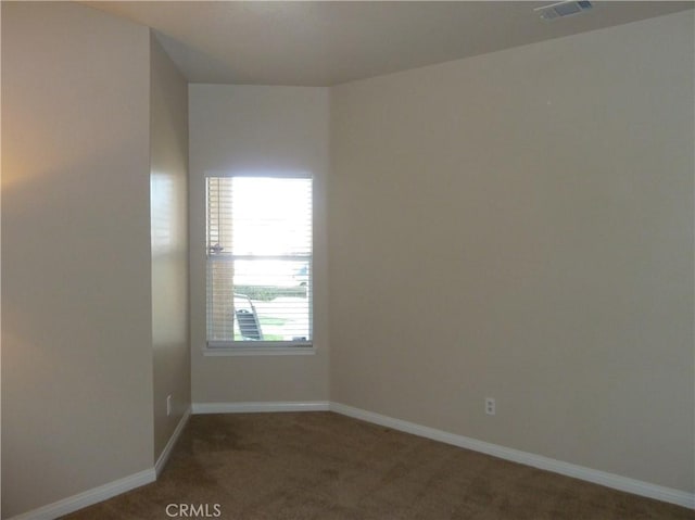 carpeted spare room with visible vents and baseboards