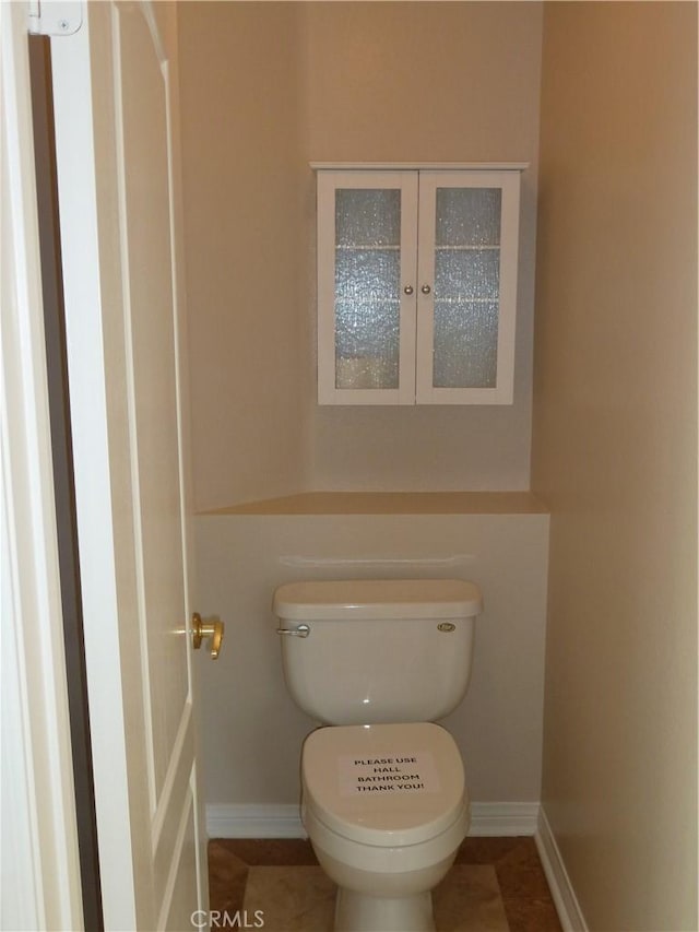 bathroom featuring toilet and baseboards