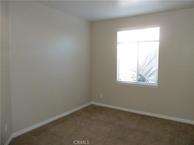 carpeted spare room with baseboards